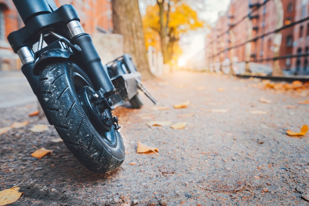 Close up of e-scooter front wheel tire parked outdoor in autumn season. Hamburg, Germany, Europe